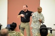 FBI Special Agent Michael Culloton, left, and Lt. Col. Tim Tyler, chief financial officer with the 416th Theater Engineer Command (TEC) and Illinois State Trooper, demonstrate proper movement techniques with the M9 pistol, during active shooter training at the 416th TEC headquarters, Darien, Ill. The training provided by Special Agent Culloton gave Soldiers tools to react and protect themselves in an active shooter situation, Aug. 6, 2016. (U.S. Army photo by Spc. Brianna Saville/Released)