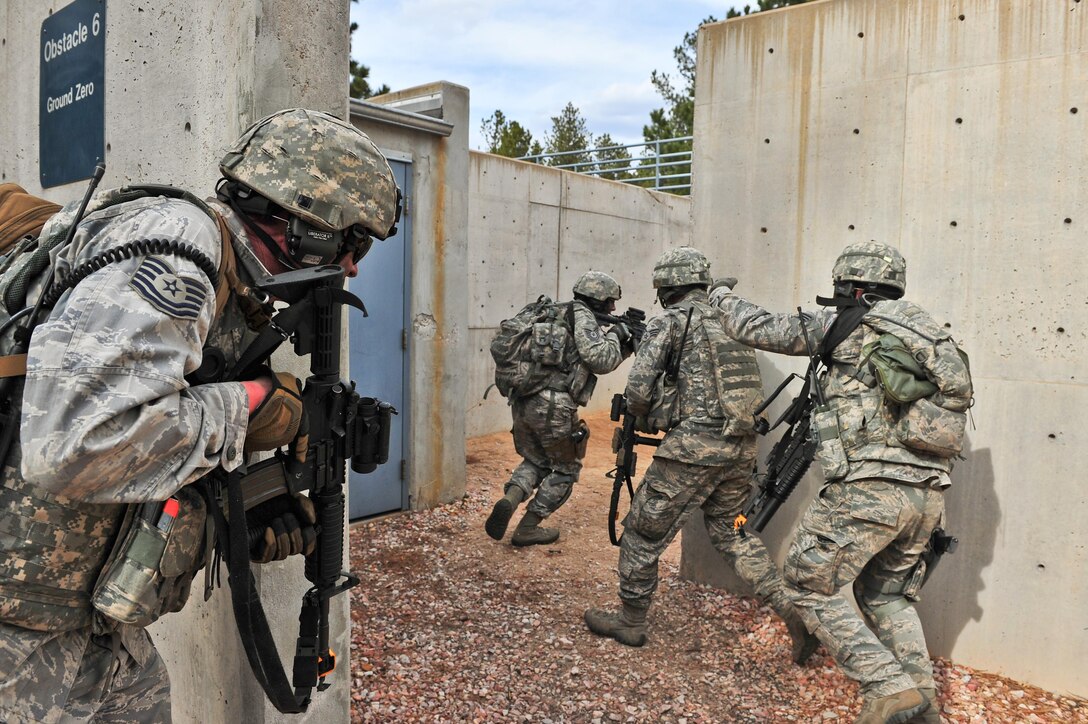 Air Force Reserve security forces members storm an enemy compound during a training mission April 9, 2014, at the U.S. Air Force Academy in Colorado Springs, Colo. The 710th and 310th Security Forces Squadrons held a six-day combat leaders course while living in field conditions. Each day’s mission is designed around the main objective of the day’s classroom instruction, placing practical application of combat maneuvers into complex mission environments. The 710th SFS is out of Buckley Air Force Base, Colo., and the 310th SFS is out of Schriever AFB. (U.S. Air Force photo/Tech. Sgt. Nicholas B. Ontiveros) 