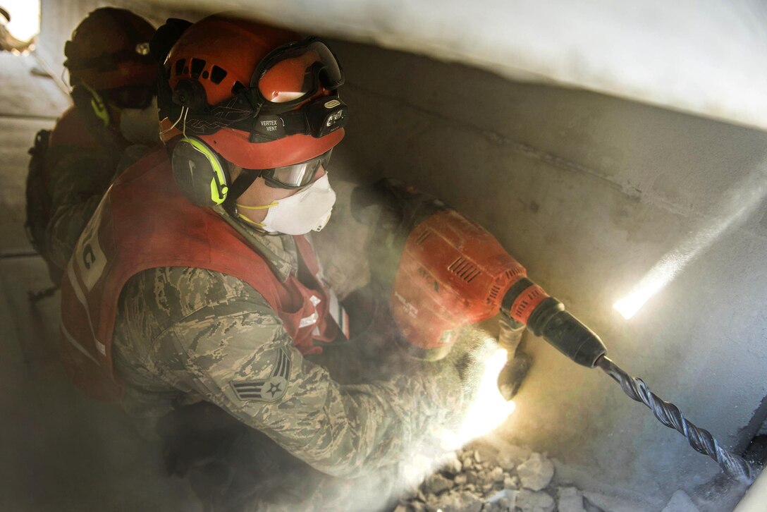 Airmen use a concrete drill to make a hole through a wall to search for possible simulated casualties during a training scenario as part of Vigilant Guard 2016 at Camp Johnson in Colchester, Vt., July 30, 2016. Air National Guard photo by Senior Airman Jonathon Alderman