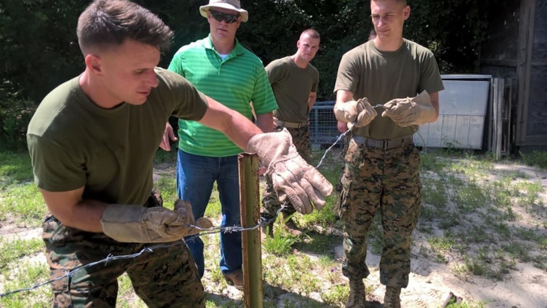 On July 20, 2016 First Lieutenant Jean-Luc Currie and Second Lieutenant John Bayko, Marines attached to Combat Engineer Officer course 6-16 (CEO 6-16); learn the basics and get hands-on experience in constructing a four strand cattle fence as Mr. Eric Schnitzler, an instructor with Combat Engineer Instruction Company; ensures the students are performing the techniques properly. 
