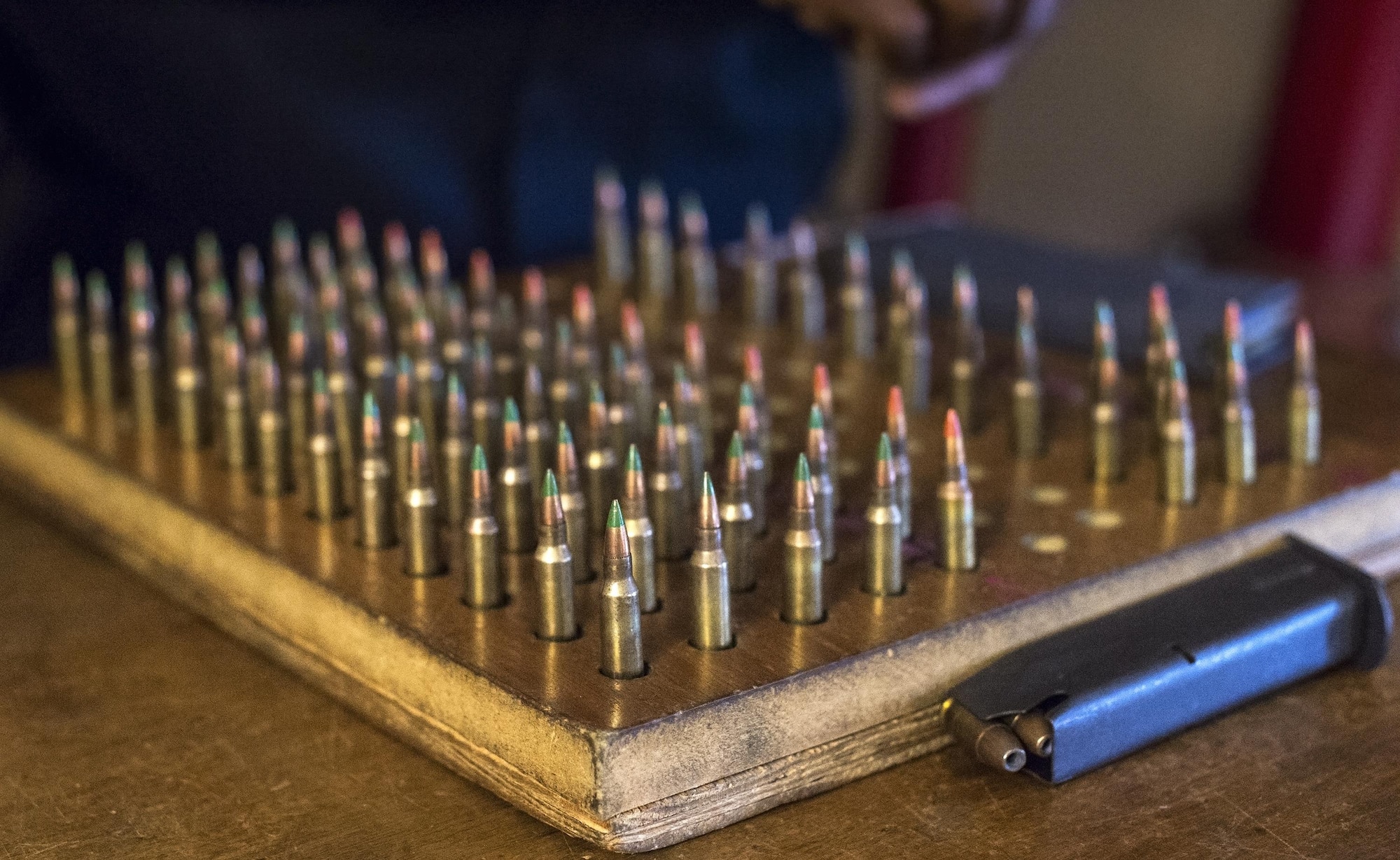 Ammunition rests in a slotted piece of wood, Aug. 9, 2016, at Moody Air Force Base, Ga. The green tip on the round indicates a regular round, while the orange tip indicates a tracer round. When security forces personnel load their magazines they start with four green tipped rounds and then a tracer round. Tracer rounds have a pyrotechnic charge in their base that emit a bright light so personnel can see where they’re firing. (U.S. Air Force photo by Airman 1st Class Robinson)