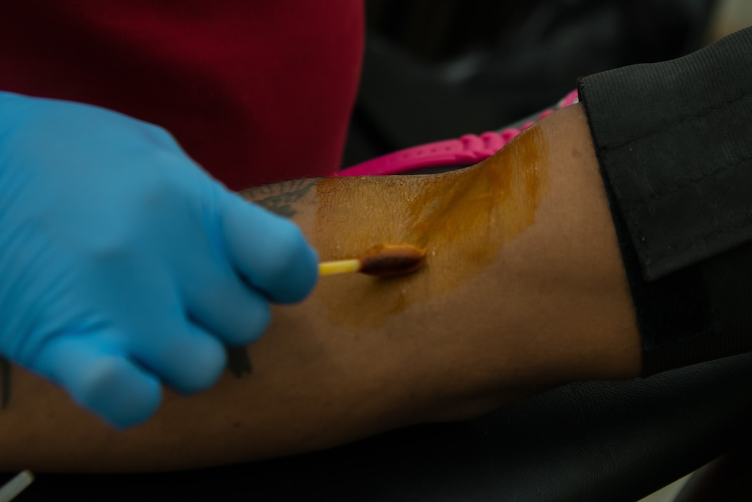 Felicia Taylor, American Red Cross phlebotomist collection technician three, cleans the arm of Spc. Curtis Smith, 335th Transportation Detachment watercraft operator, with iodine during a blood drive at Fort Eustis, Va., August 3, 2016. Iodine products are used to reduce bacterial loads such as bacteria, fungi, protozoa and viruses. (U.S. Air Force photo by Staff Sgt. J.D. Strong II)