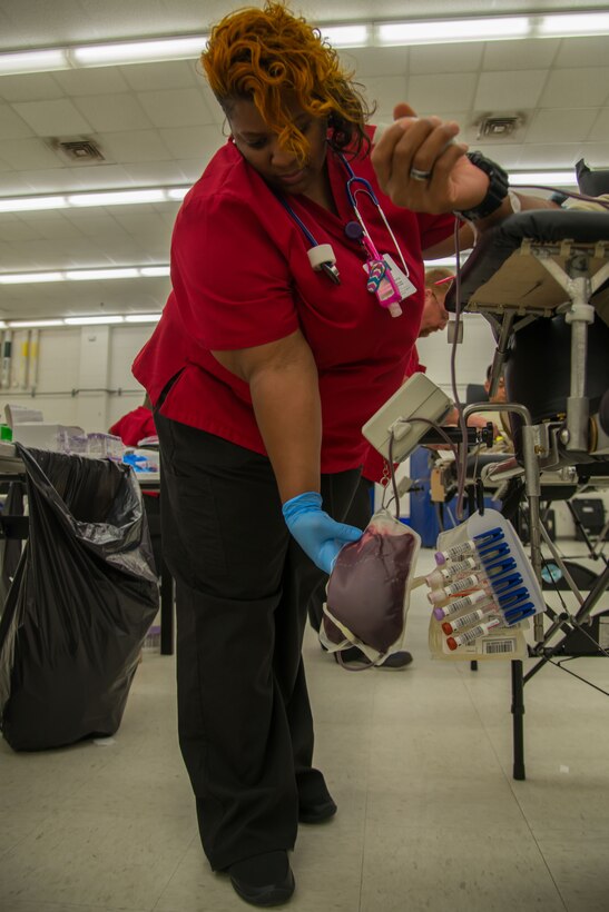 Felicia Taylor, American Red Cross phlebotomist collection technician three, checks the amount of blood in a bag during a blood drive at Fort Eustis, Va., August 3, 2016. Taylor has worked as a phlebotomist for over 18 years. (U.S. Air Force photo by Staff Sgt. J.D. Strong II)