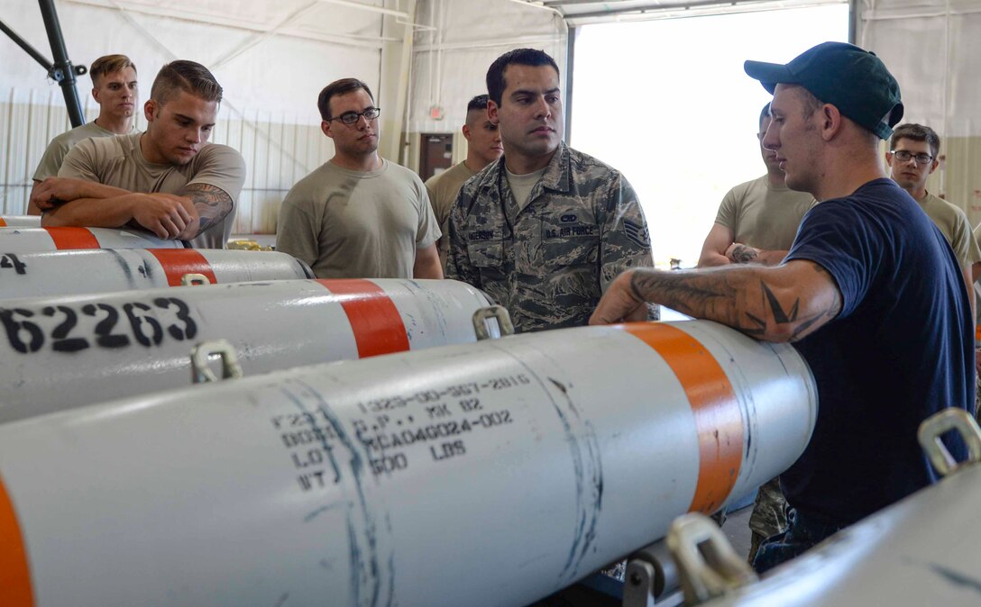 Airmen assigned to the 28th Munitions Squadron receive instruction from Petty Officer Second Class Nick Werner, a minesman assigned to the Navy Munitions Command Atlantic Unit, Charleston, S.C., at Ellsworth Air Force Base, S.D., July 20, 2016. Airmen trained with Sailors to build approximately 60 500-pound inert mines as well as two 2,000-pound inert mines. (U.S. Air Force photo by Airman 1st Class Sadie Colbert)