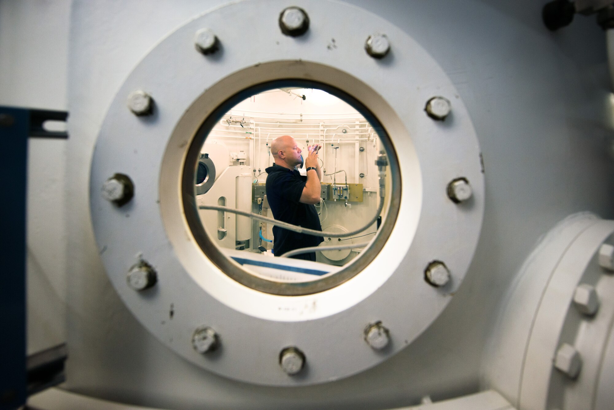 Creighton Carrow, 660th Aircraft Maintenance Squadron honorary commander, takes a photograph inside the hyperbaric multiplace chamber during a tour of David Grant USAF Medical Center at Travis Air Force Base, Calif., July 29, 2016. The purpose of the Travis Air Force Base Honorary Commander Program is to promote relationships between base senior leadership and civilian partners, foster civic appreciation of the Air Force mission and its Airmen, maximize opportunities to share the Air Force story with new stewards, and to communicate mutual interest, challenges, and concerns that senior leaders and civilian stakeholders have in common. (U.S. Air Force photo by Louis Briscese)