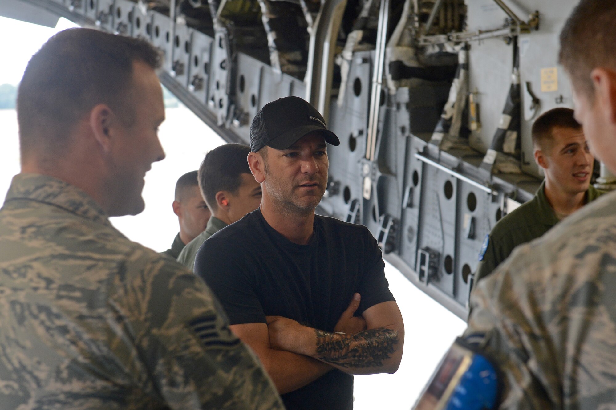 Craig Campbell (center), an American country music singer, visits with Airmen from Team McChord during his United Service Organization tour August 9, 2016 at Joint Base Lewis-McChord, Wash. While visiting McChord Field, Campbell had the opportunity to talk to 62nd Maintenance Group Airmen and loadmasters while touring a McChord C-17 Globemaster III. Later that day, as part of his tour, Campbell performed at Memorial Stadium on JBLM and thanked the men and women of JBLM for their service. (U.S. Air Force photo/Senior Airman Divine Cox)