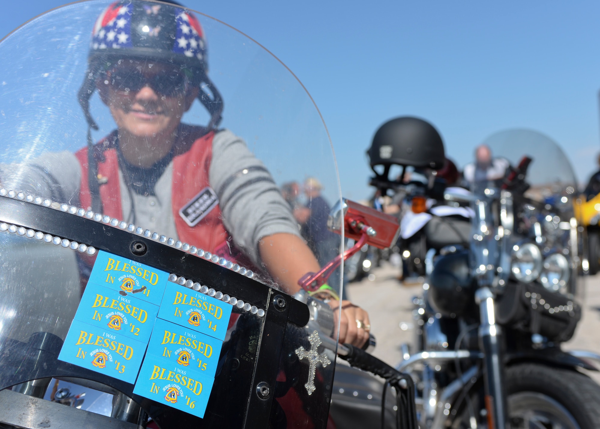 Mary Faatz, motorcycle enthusiast from Rapid City, S.D., parks her motorcycle outside the Pride Hangar during the 16th Annual Dakota Thunder Run at Ellsworth Air Force Base, S.D., Aug. 9, 2016. Faatz has been participating in the ride with her sisters for six consecutive years and displays proudly the blessed stickers she has accumulated each year she has ridden in this event. (U.S. Air Force photo by Senior Airman Anania Tekurio/Released)