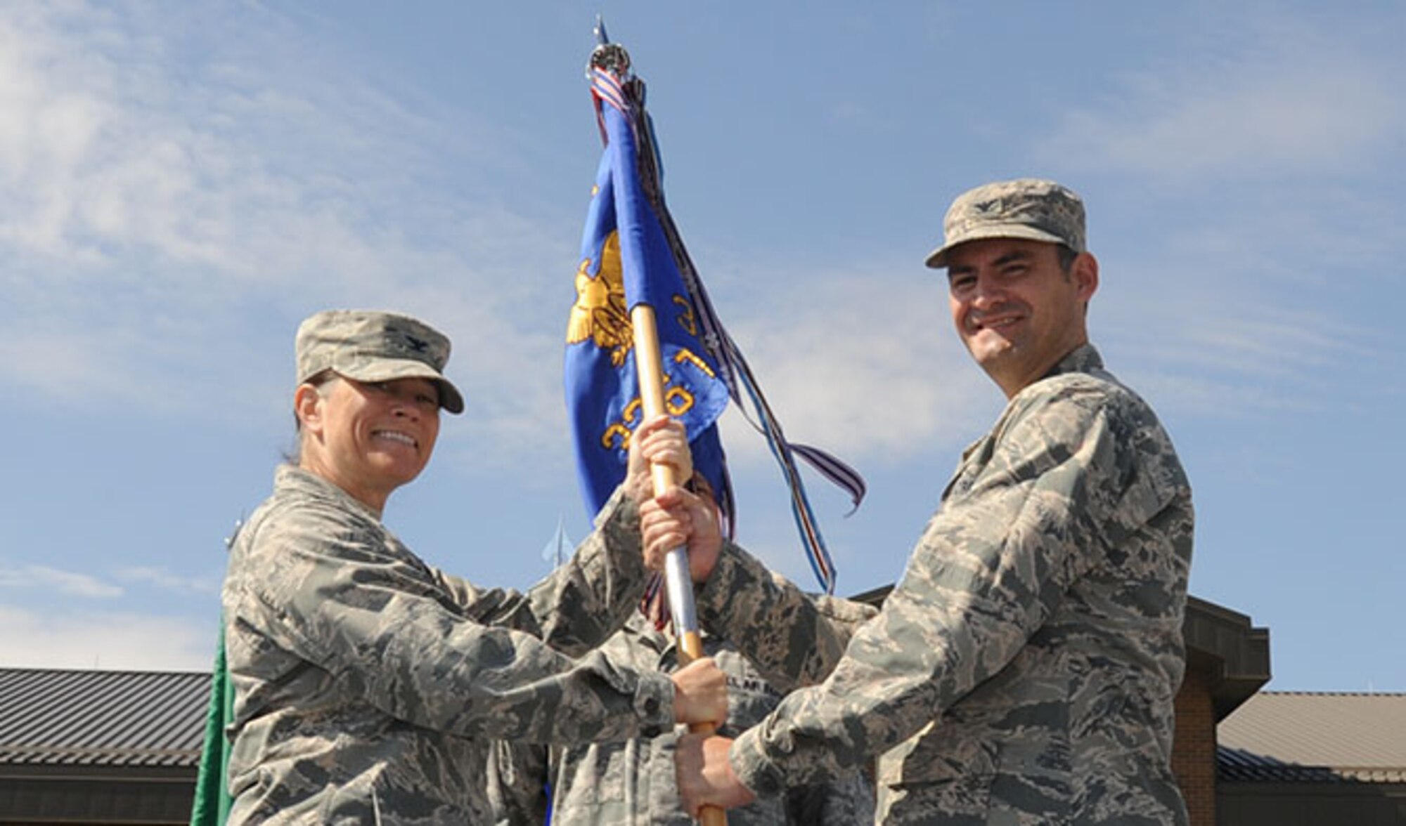 Col. Brenda Cartier, 58th Special Operations Wing commander, passes the 336th Training Group guidon to Col. John Groves, 336th TRG commander, during the change of command ceremony Aug. 10, 2016, at Fairchild Air Force Base, Wash. Groves was previously chief of the Office of Security Cooperation at the U.S. Embassy in Tegucigalpa, Honduras. (U.S. Air Force photo/Senior Airman Sam Fogleman)