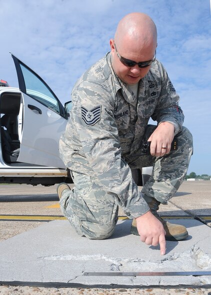 Tech Sgt. Nathan Strickland, 2nd Operations Support Squadron NCO in charge airfield management operations, identifies damaged pavement on the flightline at Barksdale Air Force Base, La., August 9, 2016. When there is damaged pavement, Airfield Management calls the 2nd Civil Engineer Squadron to repair it. Damaged pavement poses a risk for planes taking off or landing. (U.S. Air Force Photo/Airman 1st Class Stuart Bright)