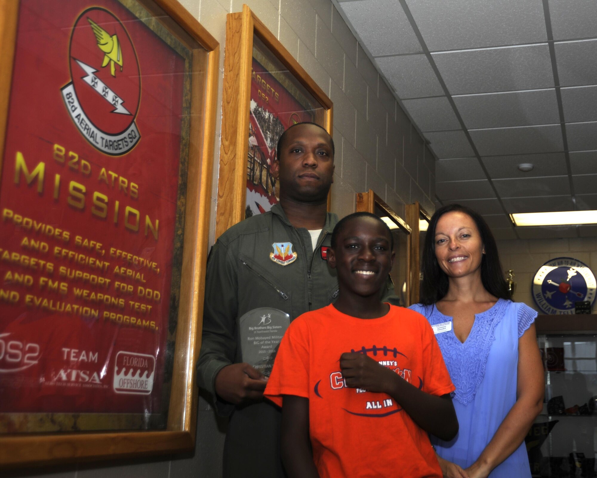 U.S. Air Force Senior Airman Christian Smith, 82nd Aerial Target Squadron E-9 systems operator, Jaylon, Little Brother, and Leanne Gaudet, Bay County case manager for Big Brother Big Sister of Northwest Florida, stand together after Smith received the Ron Mobayed Military Big of the Year Award at Tyndall Air Force Base, Aug. 9, 2016. The Ron Mobayed Award was established as a memorial to the life of Lt. Ronald Joseph Mobayed. The award is intended for military members who volunteer in the BBBS. (U.S. Air Force photo by Senior Airman Solomon Cook/Released)