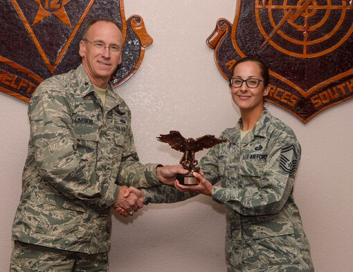 Brig. Gen. Donald Lindberg, Mobilization Assistant to the 12th Air Force (AFSOUTH) Commander, presents Senior Master Sgt. Leah Chavez, 12 AF (AFSOUTH) A1 Contingency Plans & Operations Manager, with the 2015 Air Combat Command Force Support Senior Noncommissioned Officer of the Year for the Air Reserve Component award at Davis-Monthan AFB, Ariz. Aug. 8, 2016.  (U.S. Air Force photo by Tech. Sgt. Heather Redman)