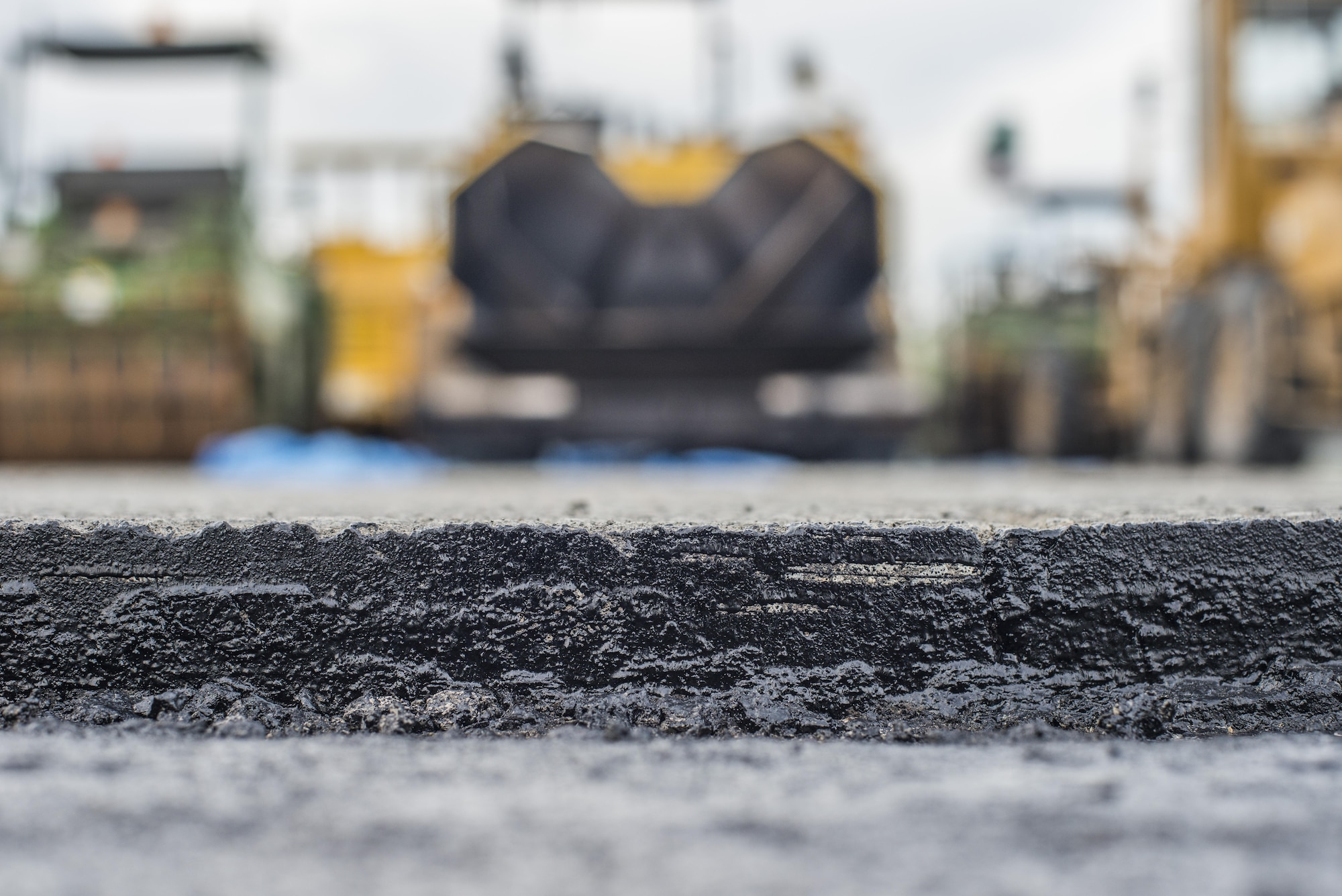 A layer of asphalt on the flightline is exposed at Misawa Air Base, Japan, Jul. 26, 2016. Due to the high volume of aircraft using the runway, the west section’s pavement surface was highly degraded, resulting in a need for a repairs. The 3,840 cubic meters of asphalt laid on the flightline spans a surface length of approximately 1,200 feet by 150 feet wide, with 50 feet of shoulder width. (U.S. Air Force photo by Senior Airman Brittany A. Chase)