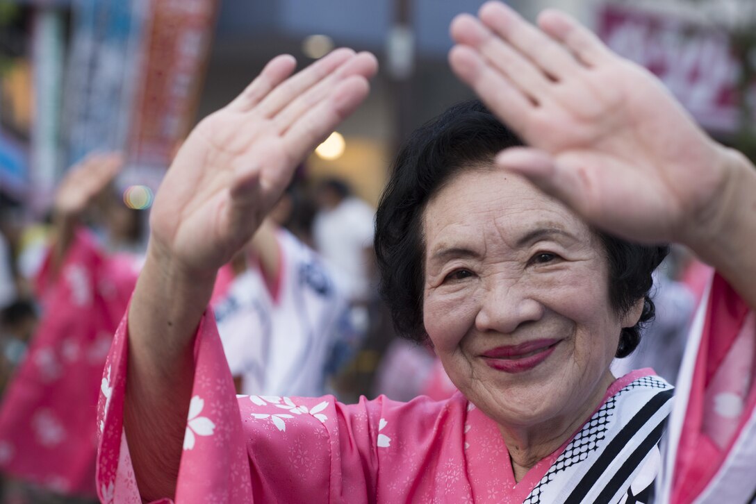 A woman wearing a traditional Japanese yukata dances during the 66th Annual Fussa Tanabata Festival at Fussa City, Japan, Aug. 5, 2016. Every year, members of Yokota Air Base participate in the festival by carrying a mikoshi, or portable shrine, dancing in a parade and eating local foods and drinks. (U.S. Air Force photo by Staff Sgt. Cody H. Ramirez/ Released)