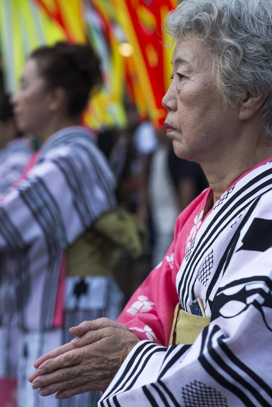 A woman wearing a traditional Japanese yukata dances during the 66th Annual Fussa Tanabata Festival at Fussa City, Japan, Aug. 5, 2016. Every year, members of Yokota Air Base participate in the festival by carrying a mikoshi, or portable shrine, dancing in a parade and eating local foods and drinks. (U.S. Air Force photo by Staff Sgt. Cody H. Ramirez/ Released)