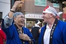 A member of the Yokota-Fussa Friendship Club talks with Col. Kenneth Moss, 374th Airlift Wing commander, during the 66th Annual Tanabata Festival at Fussa City, Japan, Aug. 5, 2016. Moss participated in carrying a mikoshi, or portable shrine, during the festival, along with nearly 100 other volunteers from Yokota Air Base. (U.S. Air Force photo by Staff Sgt. Cody H. Ramirez/Released)