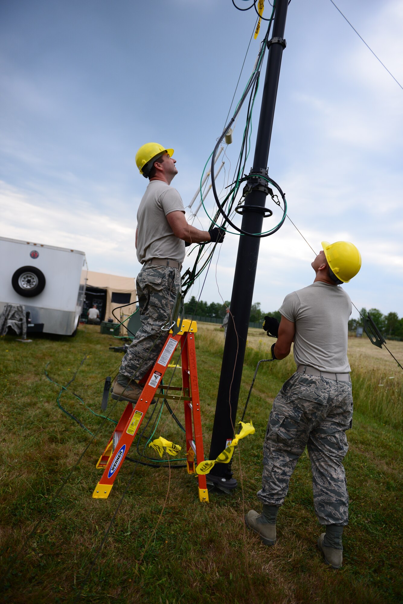 From the left, Senior Airman Robert Bell, and Senior Airman Matthew Barricklow, both from the 157th Communications Flight, adjust the height of a radio communication antenna during a training exercise at the New Hampshire Air National Guard Training Site in Center Stratford, N.H., Aug. 6. The antenna was part of the Joint Incident Site Communications Capability (JISCC) that was used to execute the exercise in support of domestic operations. (Air National Guard photo by Senior Airmen Kayla McWalter)  
