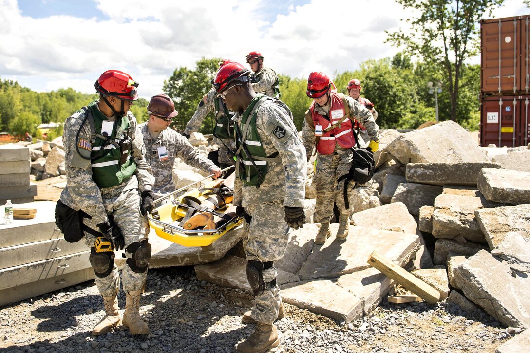 Guardsmen carry a stretcher with a simulated casualty they rescued from rubble during a training scenario as part of Vigilant Guard 2016 at Camp Johnson, Colchester, Vt., July 30, 2016. Air National Guard photo by Senior Airman Jonathon Alderman