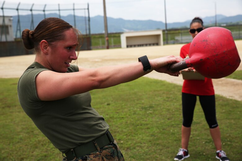 U.S. Marine Corps 2nd Lt. Melissa Heisterberg, deputy director of public affairs, Headquarters and Headquarters Squadron,  performs kettle bell swings during the preliminary High Intensity Tactical Training Athlete Competition at Marine Corps Air Station Iwakuni, Japan, June 17, 2016. Heisterberg is the top female contender from the air station to attend the Second Annual HITT Ultimate Athlete Championship from Aug. 15-18, 2016, at MCAS Miramar, California. This year’s HITT Ultimate Athlete Championship is expected to include roughly 30 endeavors imbedded in the main course events: The 500 yard power shuttle, 500 yard battle skills challenge, the amphibious tactical challenge, the maneuver under fire tactical course, and the culminating tactical fitness challenge. (U.S. Marine Corps photo by Sgt. Jessica Quezada)