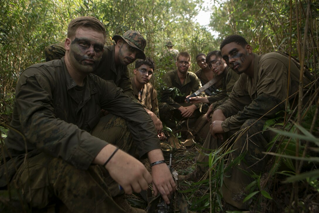 Marines with India Company, 3rd Battalion, 3rd Marine Regiment take a break Aug. 3 at the Jungle Warfare Training Center on Okinawa, Japan. As they wait for their resupply for water, they sit in the brush wearing their test Marine Corps combat utility uniforms. The new uniforms and boots are supposed to be lighter and faster to dry. 