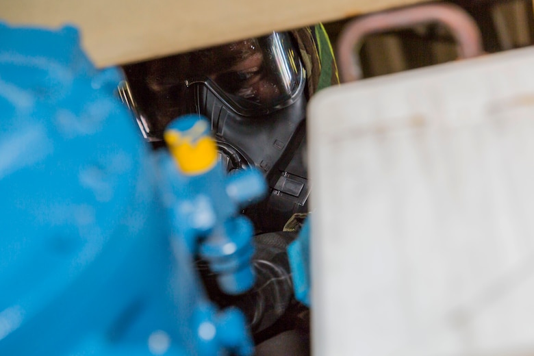 A U.S. Marine with Combat Logistics Company 36 inspects equipment during chemical, biological, radiological and nuclear defense training at Marine Corps Air Station Iwakuni, Japan, Aug. 10, 2016. Marines, already in mission oriented protective posture gear, were evaluated on their ability to effectively detect, report, respond and operate in a simulated CBRN environment. When given the signal “gas, gas, gas,” Marines scrambled to don their M50 Joint Service General Purpose Masks before returning to work as if everything was normal. The training tested CLC-36’s effectiveness, personnel and equipment under CBRN conditions, and reinforced individual confidence in the use and implementation of personal protective equipment. (U.S. Marine Corps photo by Lance Cpl. Aaron Henson)
