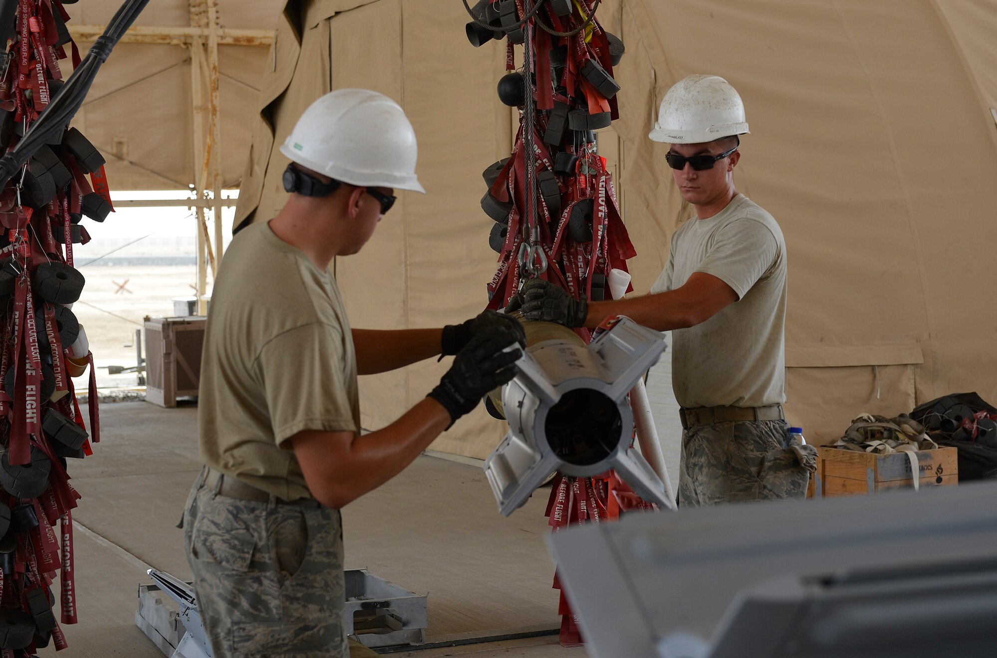Munitions Airmen assigned to the 380th Expeditionary Maintenance Squadron move bombs from a rapid assembly conveyer at an undisclosed location. Over 2,000 munitions have been built and employed on enemy targets since the beginning of 2016. (U.S. Air Force Photo by Capt. Sybil Taunton)