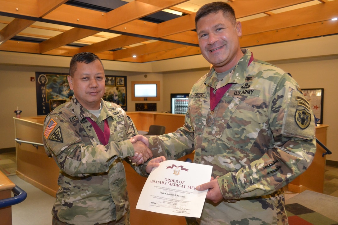 Army Maj. Randall Sweeney (right) is inducted into the Order of Military Medical Merit Aug. 4 by Col. Alex Zotomayor, director of DLA Troop Support's Medical supply chain. Sweeney is the chief pharmacist for Medical's Customer Pharmacy Operations Center