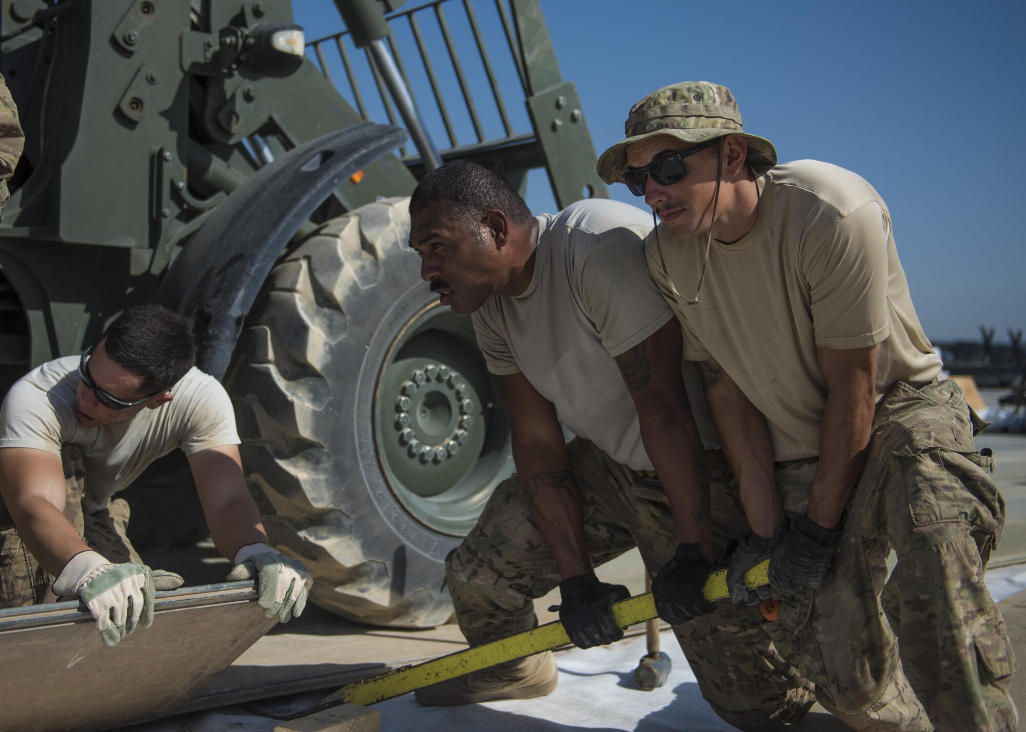 Members of the Members of the 455th Expeditionary Civil Engineer Squadron align a piece of AM-2 Matting, Bagram Airfield, Afghanistan, Aug. 11, 2016. AM-2 matting is used to form runways, taxiways, parking and other areas required for aircraft operations and maintenance. (U.S. Air Force photo by Senior Airman Justyn M. Freeman)