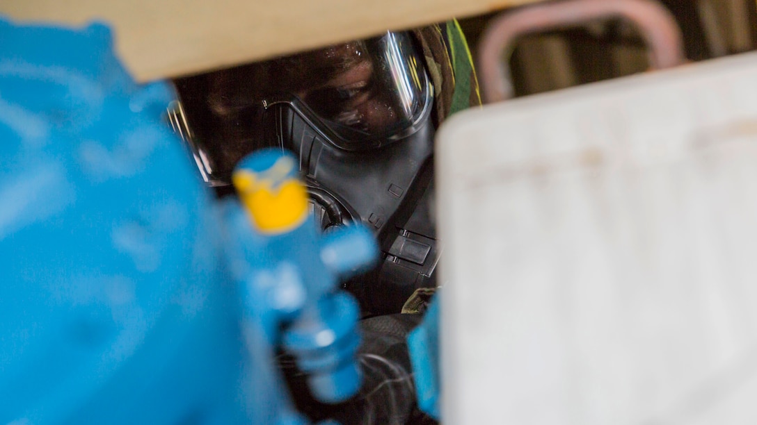 A U.S. Marine with Combat Logistics Company 36 inspects equipment during chemical, biological, radiological and nuclear defense training at Marine Corps Air Station Iwakuni, Japan, August 10, 2016. Marines, already in mission oriented protective posture gear, were evaluated on their ability to effectively detect, report, respond and operate in a simulated CBRN environment. When given the signal “gas, gas, gas,” Marines scrambled to don their M50 Joint Service General Purpose Masks before returning to work as if everything was normal. The training tested CLC-36’s effectiveness, personnel and equipment under CBRN conditions, and reinforced individual confidence in the use and implementation of personal protective equipment. 