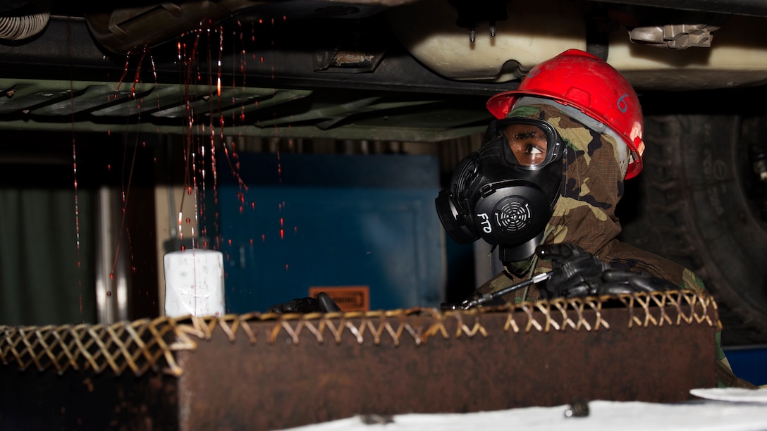 U.S. Marine Corps Sgt. Lamarcus Williams, motor transportation mechanic and quality control chief with Combat Logistics Company 36, drains the transmission fluid from a high mobility multipurpose wheeled vehicle during chemical, biological, radiological and nuclear defense training at Marine Corps Air Station Iwakuni, Japan, August 10, 2016. Marines, already in mission oriented protective posture gear, were evaluated on their ability to effectively detect, report, respond and operate in a simulated CBRN environment. When given the signal “gas, gas, gas,” Marines scrambled to don their M50 Joint Service General Purpose Masks before returning to work as if everything was normal. 