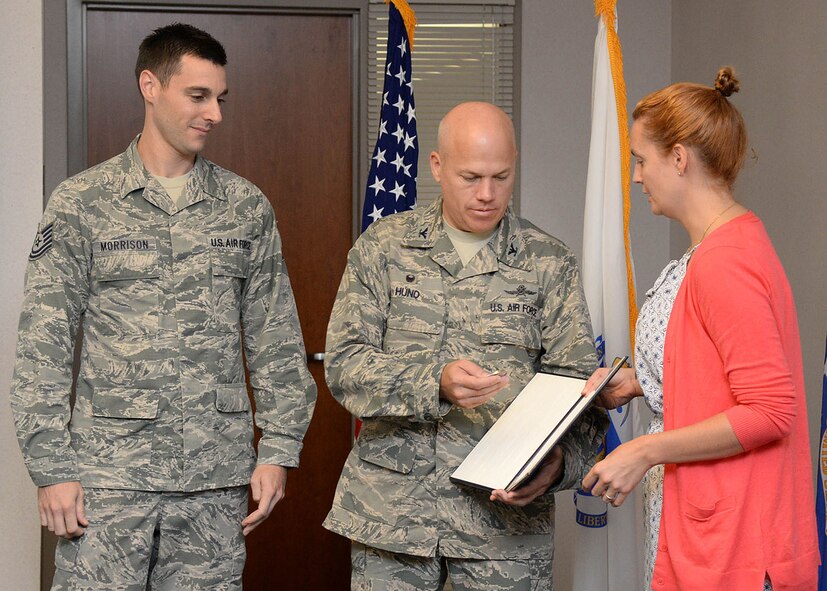 Emily Gilmore, right, Combined Federal Campaign director,  presents the CFC Outstanding Achievement Award to Col. Roman L. Hund, center, installation commander, and Tech. Sgt. Justin Morrison, a CFC installation project officer last fall, at Hanscom Air Force Base, Mass., Aug 11. The award was presented to Hanscom AFB by the CFC campaign director for an increase in fundraising during last year's campaign.  (U.S. Air Force photo by Linda LaBonte Britt)