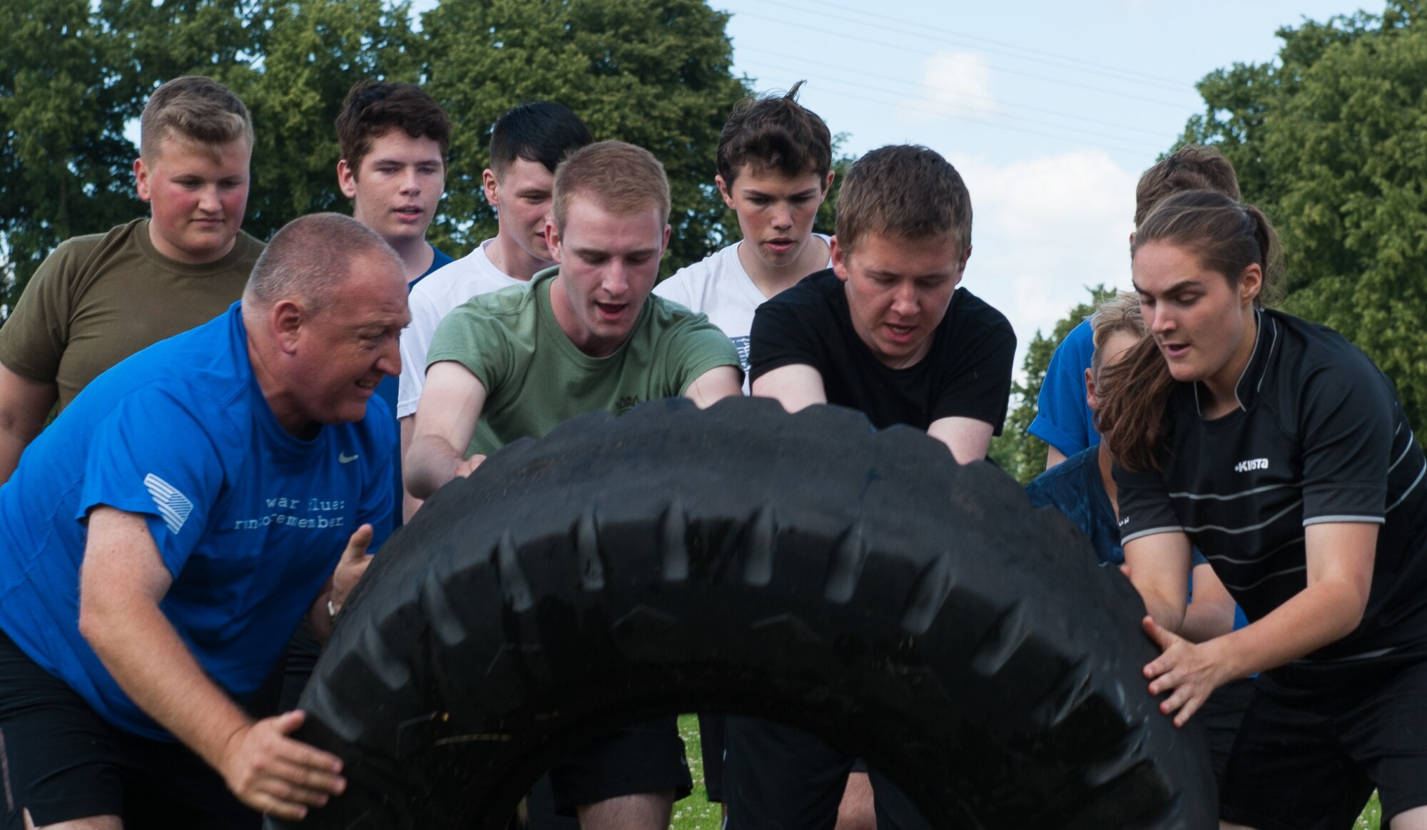 Royal Air Force cadets flip a tire during Warrior Day, a physical regimen hosted by the Kisling NCO Academy Aug. 8, at Vogelweh Military Complex, Germany.  Warrior Day is an annual mentorship program between the Air Force and the United Kingdom, where NCOA cadre provide insight on how Airmen train and stay educated. This event serves as a way for the U.S. continues to strengthen its relationship with the U.K. by showing the air cadets how the Kaiserslautern Military Community works together and through physical exercises. (U.S. Air force photo/Airman 1st Class Lane T. Plummer)