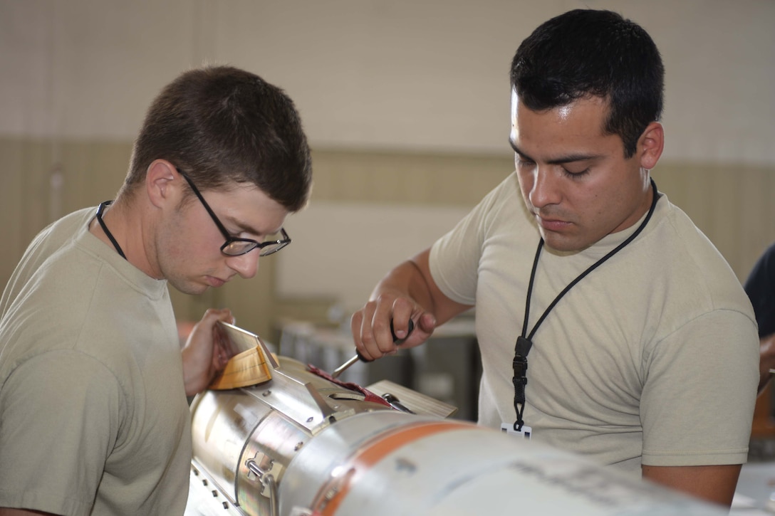 Airman 1st Class Forrest Roach, a conventional maintenance crewmember, left, works with Staff Sgt. Anthony Anderson, a conventional maintenance crew chief and munitions inspector, to attach a fin to an MK 62 mine at Ellsworth Air Force Base, S.D., July 20, 2016. Both men are assigned to the 28th Munitions Squadron. Air Force photo by Airman 1st Class Sadie Colbert