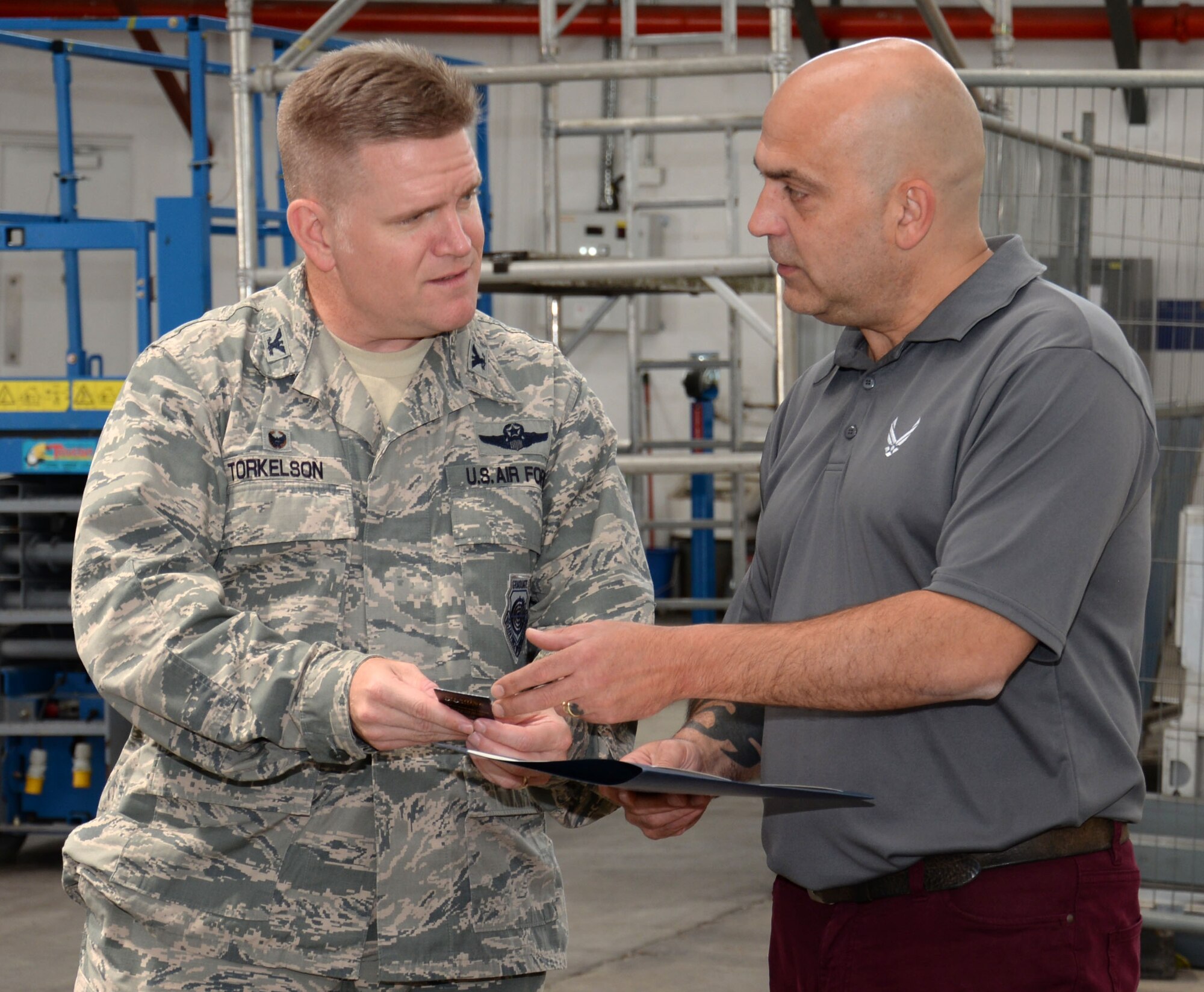 Steven Randall, right, 100th Logistics Readiness Squadron distribution manager, receives a pin for 30 years of service to the U.S. government from U.S. Air Force Col. Thomas Torkelson, 100th Air Refueling Wing commander, Aug. 10, 2016, on RAF Mildenhall, England. Randall began employment on RAF Mildenhall in 1996 after working at RAF Lakenheath for 10 years, and currently runs the cargo movement and vehicle operations elements for the squadron. (U.S. Air Force photo by Gina Randall)