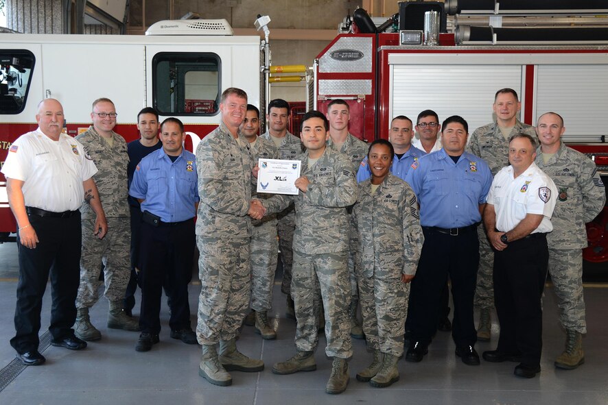 Senior Airman Rodolfo Chaira, front center, 47th Civil Engineer Squadron fire protection journeyman, accepts the “XLer of the Week” award from Col. Thomas Shank, front left, 47th Flying Training Wing commander, and Chief Master Sgt. Erica Shipp, front right, 47th Mission Support Group superintendent, here, Aug. 3, 2016. The XLer is a weekly award chosen by wing leadership and is presented to those who consistently make outstanding contributions to their unit and Laughlin. (U.S. Air Force photo/Airman 1st Class Brandon May)