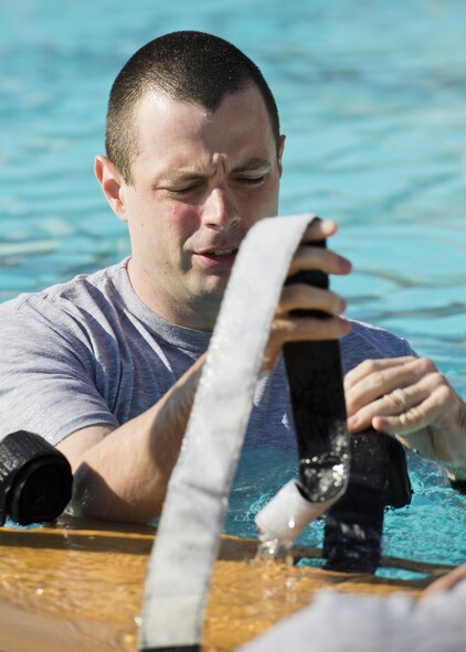 Staff Sgt. Jacob Alsteen, 5th Medical Operations Squadron emergency medical technician, untangles straps on a water rescue board during training at Minot Air Force Base, N.D., Aug. 10, 2016. The water rescue board is used to immobilize a patient while keeping them above the surface of the water during a rescue. (U.S. Air Force photo/Airman 1st Class J.T. Armstrong)