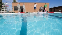 Airmen from the 5th Medical Operations Squadron prepare to practice their water extraction skills during training at the base pool at Minot Air Force Base, N.D., Aug. 10, 2016. The water extraction training involved performing emergency medicine on a simulated patient in a water environment. (U.S. Air Force photo/Airman 1st Class J.T. Armstrong)