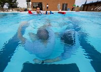 Airmen from the 5th Medical Operations Squadron swim to a simulated victim during training at the base pool at Minot Air Force Base, N.D., Aug. 10, 2016. The water extraction training demonstrated the team’s ability to perform a rescue while preventing further injury to the patient. (U.S. Air Force photo/Airman 1st Class J.T. Armstrong)