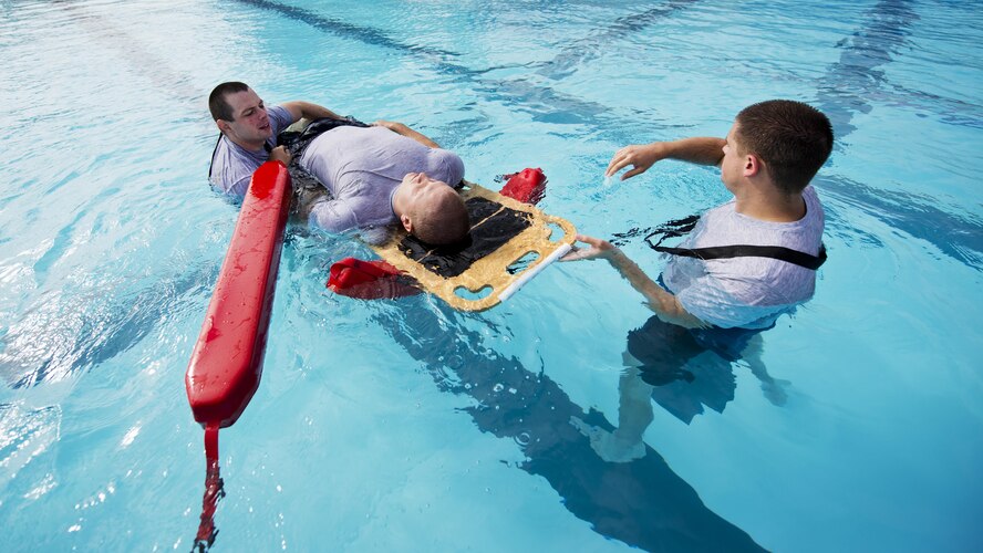 Airmen from the 5th Medical Operations Squadron move a simulated patient during training at the base pool at Minot Air Force Base, N.D., Aug. 10, 2016. A water rescue board is used in conjunction with lifeguard buoys to keep the patient above water during the rescue. (U.S. Air Force photo/Airman 1st Class J.T. Armstrong)