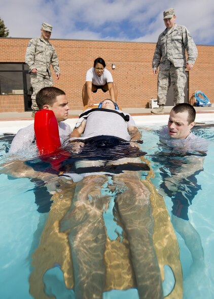 Airmen from the 5th Medical Operations Squadron extract a simulated patient during training at the base pool at Minot Air Force Base, N.D., Aug. 10, 2016. The purpose of the training was to practice for the EMT Rodeo, an Air Force-level competition held at Cannon AFB, N.M. The 5th MDOS Airmen were hand-selected to represent Air Force Global Strike Command in the competition. (U.S. Air Force photo/Airman 1st Class J.T. Armstrong)