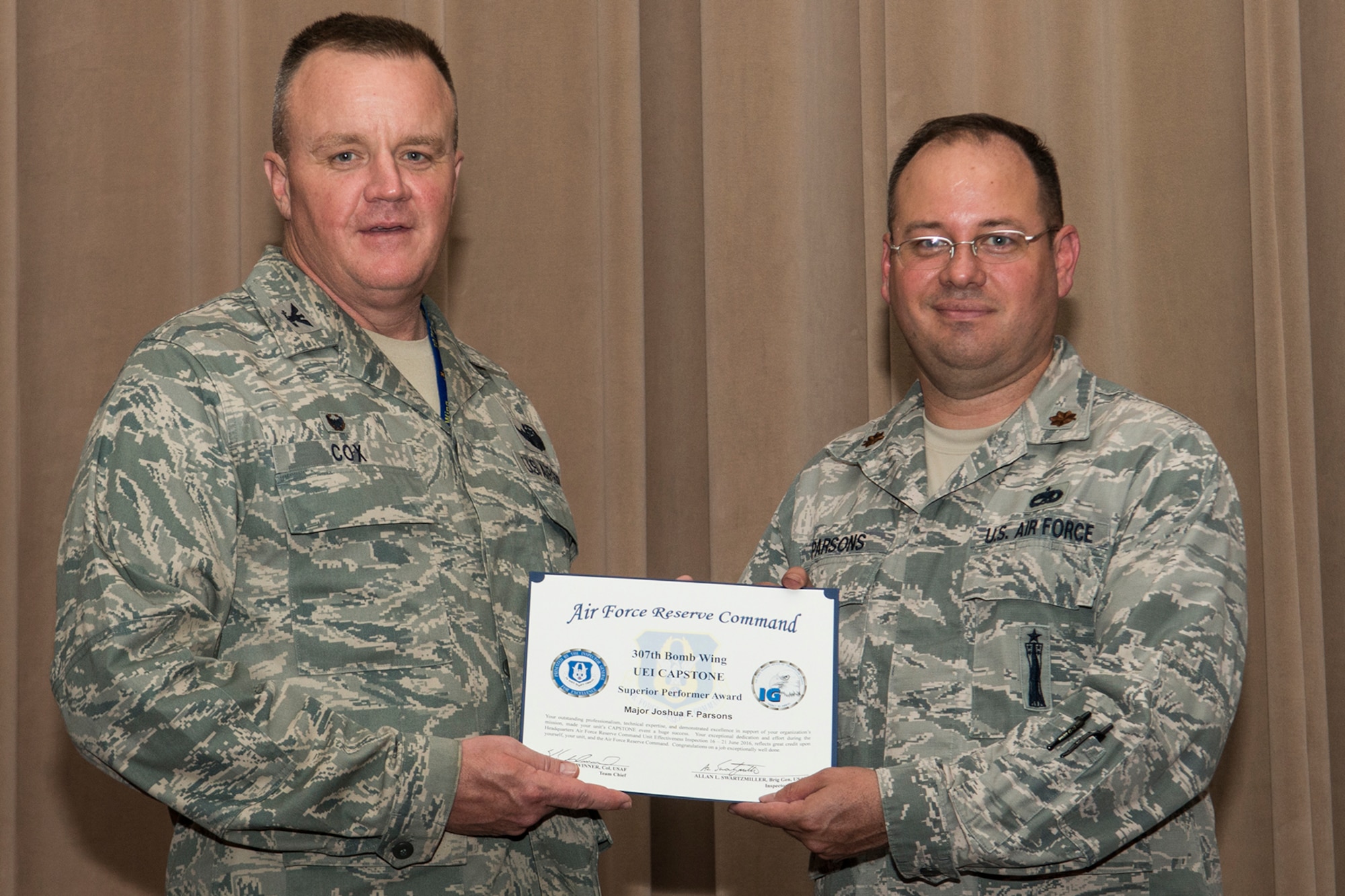 U.S. Air Force Col. Bruce Cox, 307th Bomb Wing commander, presents Maj. Josh Parsons with a Superior Performer certificate during a commander’s call on Aug. 7, 2016, Barksdale Air Force Base, La. Parson was recognized for his performance as 307th Maintenance Group Director of Staff during the Unit Effectiveness Inspection Capstone which was conducted by the Air Force Reserve Command’s Inspector General team. (U.S. Air Force photo by Master Sgt. Greg Steele/Released)