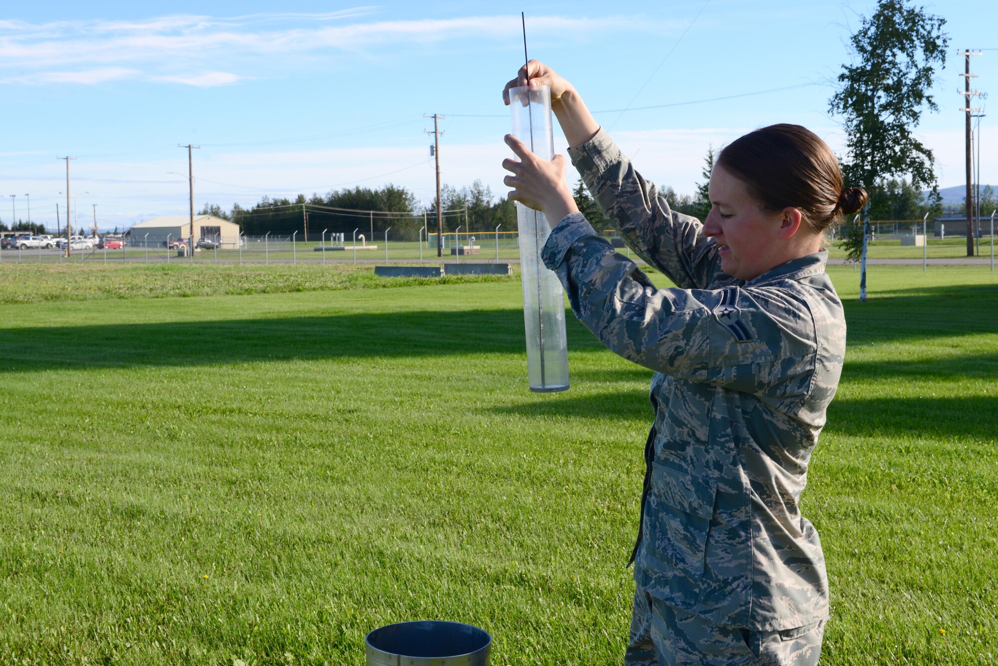 U.S. Air Force Airman 1st Class Lisa Rogers, a 354th Operations Support Squadron weather apprentice, checks for precipitation on the Eielson Air Force Base, Alaska, flight line Aug. 10, 2016, during RED FLAG-Alaska 16-3. Rogers manually checks for the precipitation level and verifies it against an automated weather machine before adding the results to observation notes. (U.S. Air Force photo by Airman 1st Class Cassandra Whitman)