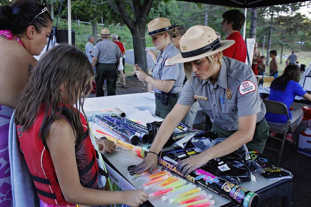 Olivia Mays, park ranger, U.S. Army Corps of Engineers, Raystown Lake, hands out glow sticks to participants of the 4th annual Glow Swim at Seven Points Beach, Aug. 6, 2016. 