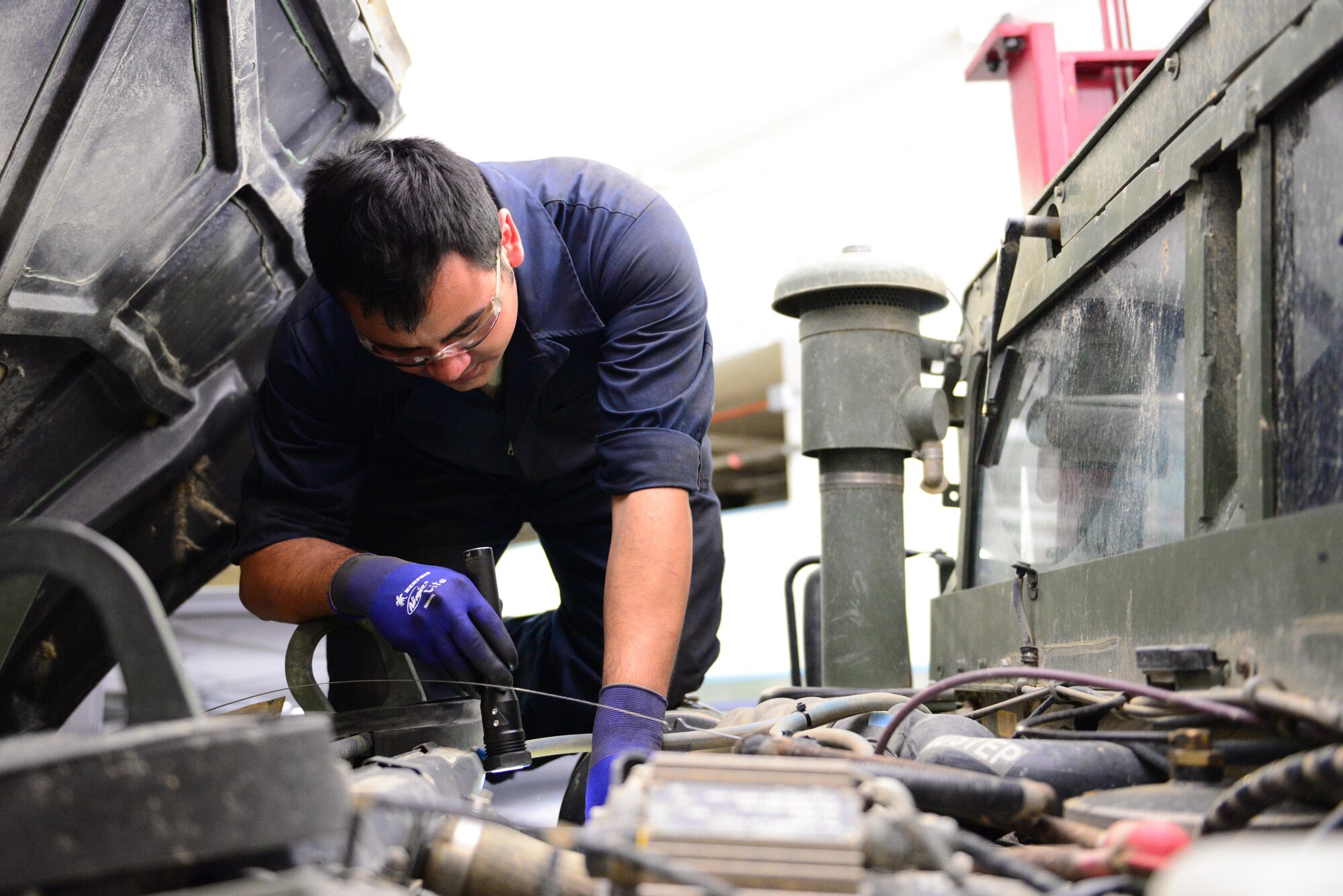 U.S. Air Force Airman 1st Class Jonathan Patino, a 354th Logistics Readiness Squadron vehicle maintenance journeyman, inspects the belt and fluids from a vehicle Aug. 10, 2016, at Eielson Air Force Base, Alaska. Patino also checks for visual damage to the vehicle before labeling it safe for use and returning it to work. (U.S. Air Force photo by Airman 1st Class Cassandra Whitman)