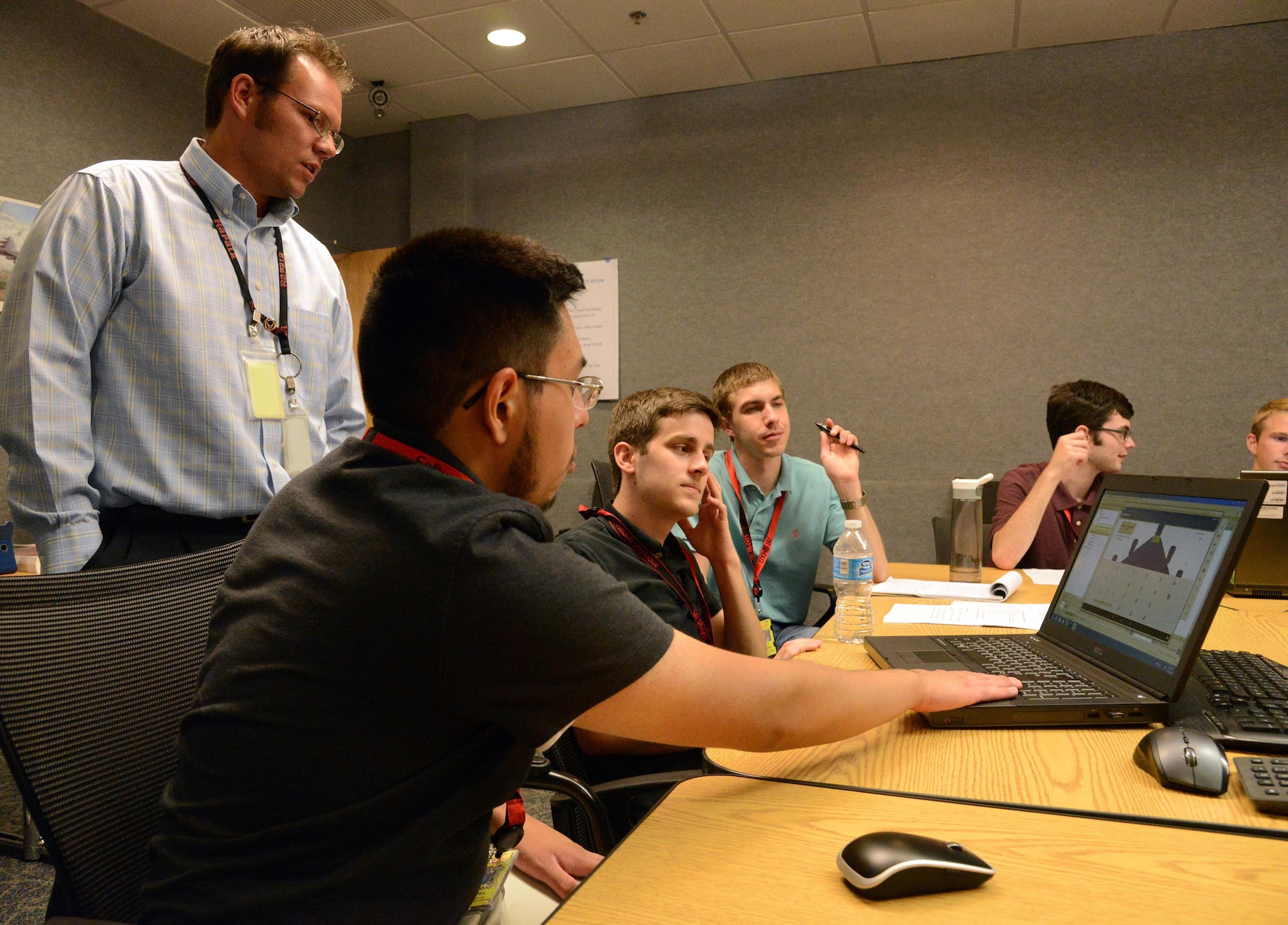 Matthew Morris, left, an electronics engineer with the 76th Software Maintenance Group and also the summer internship coordinator, observes, from left, Fernando Esquivel, Austin Harmon and Kole Erdman while they work together to design an Android application for B-52 weapons loading. (Air Force photo by Kelly White)