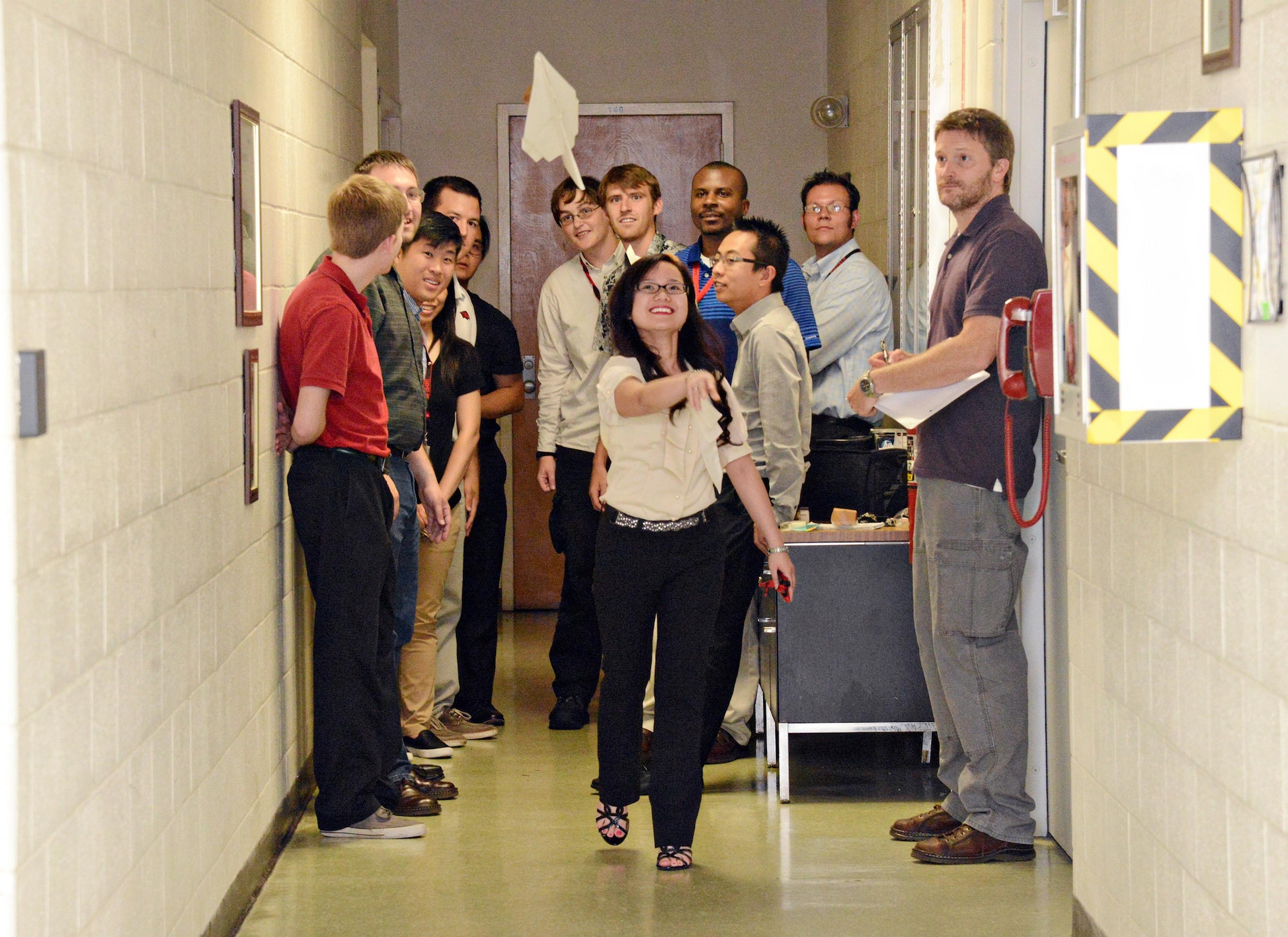Nhi Nguyen, an intern with the 76th Software Maintenance Group’s summer internship program, propels her paper airplane as part of an assignment learning about aerodynamics. The interns then had to add their version of a rotodome, similar to the E-3 AWACS, and test how it flies. (Air Force photo by Kelly White)