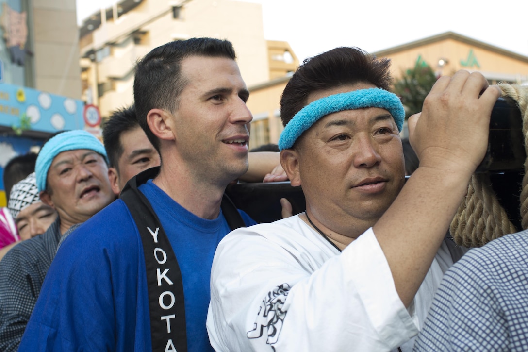 Staff Sgt. Nicholas Poe, left, 459th Airlift Squadron UH-1N Iroquois special mission aviator, joins a local community’s mikoshi shrine carry during the 66th annual Fussa Tanabata Festival at Fussa City, Japan, Aug. 5, 2016. The festival gave Yokota members an opportunity to build friendships with the local community while experiencing Japanese culture. (U.S. Air Force photo by Yasuo Osakabe/Released)