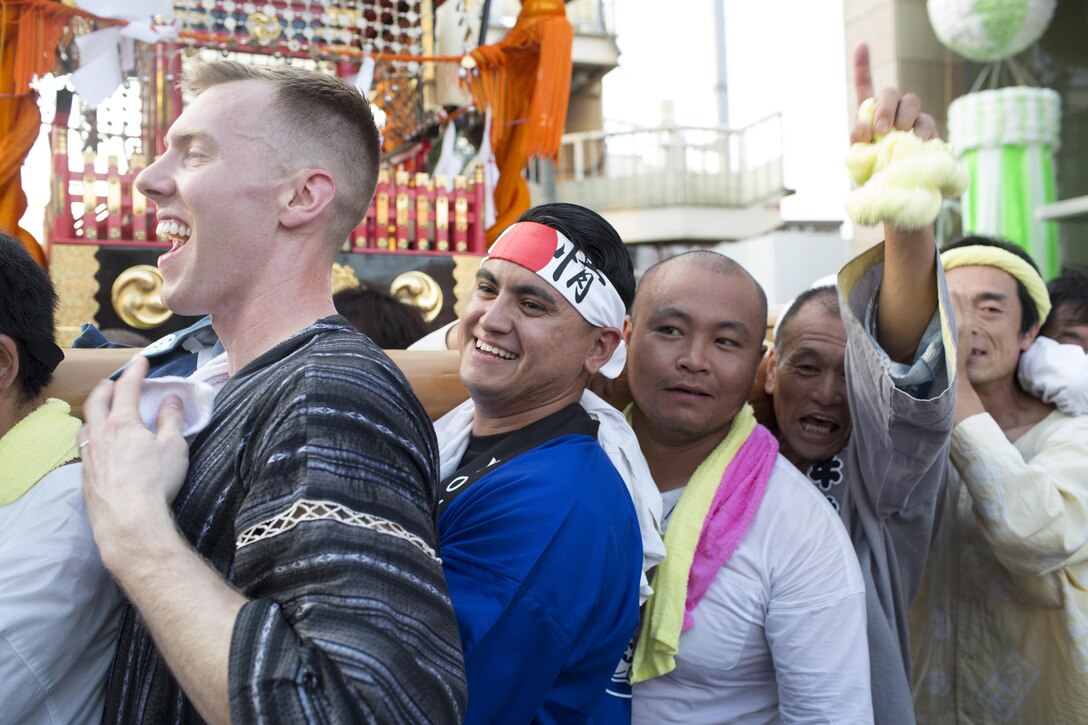 (Left to right) 1st Lt. Peter Forde, 374th Contracting Squadron deputy chief, and 1st Lt. Ben Valdez Encinas, 374th Aircraft Maintenance Squadron assistant aircraft maintenance unit officer in charge, joins a local community’s mikoshi shrine carry during the 66th annual Fussa Tanabata Festival at Fussa City, Japan, Aug. 5, 2016. The festival gave Yokota members an opportunity to build friendships with the local community while experiencing Japanese culture. (U.S. Air Force photo by Yasuo Osakabe/Released)