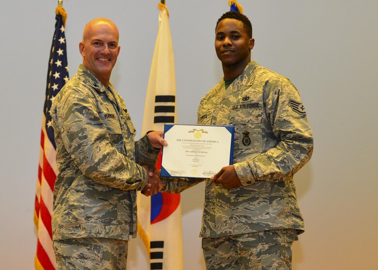 Staff Sgt. Rodney X. Dowell, 51st Security Forces Squadron information assurance NCO, poses with Col. Andrew Hansen, 51st Fighter Wing commander, after being presented with the Airman’s Medal at Osan Air Base, Republic of Korea, July 29, 2016. The Airman’s Medal is the highest non-combat medal awarded by the Air Force to individuals who distinguish themselves by heroic actions, usually at the voluntary risk of life. (U.S. Air Force photo by Senior Airman Victor J. Caputo/Released)