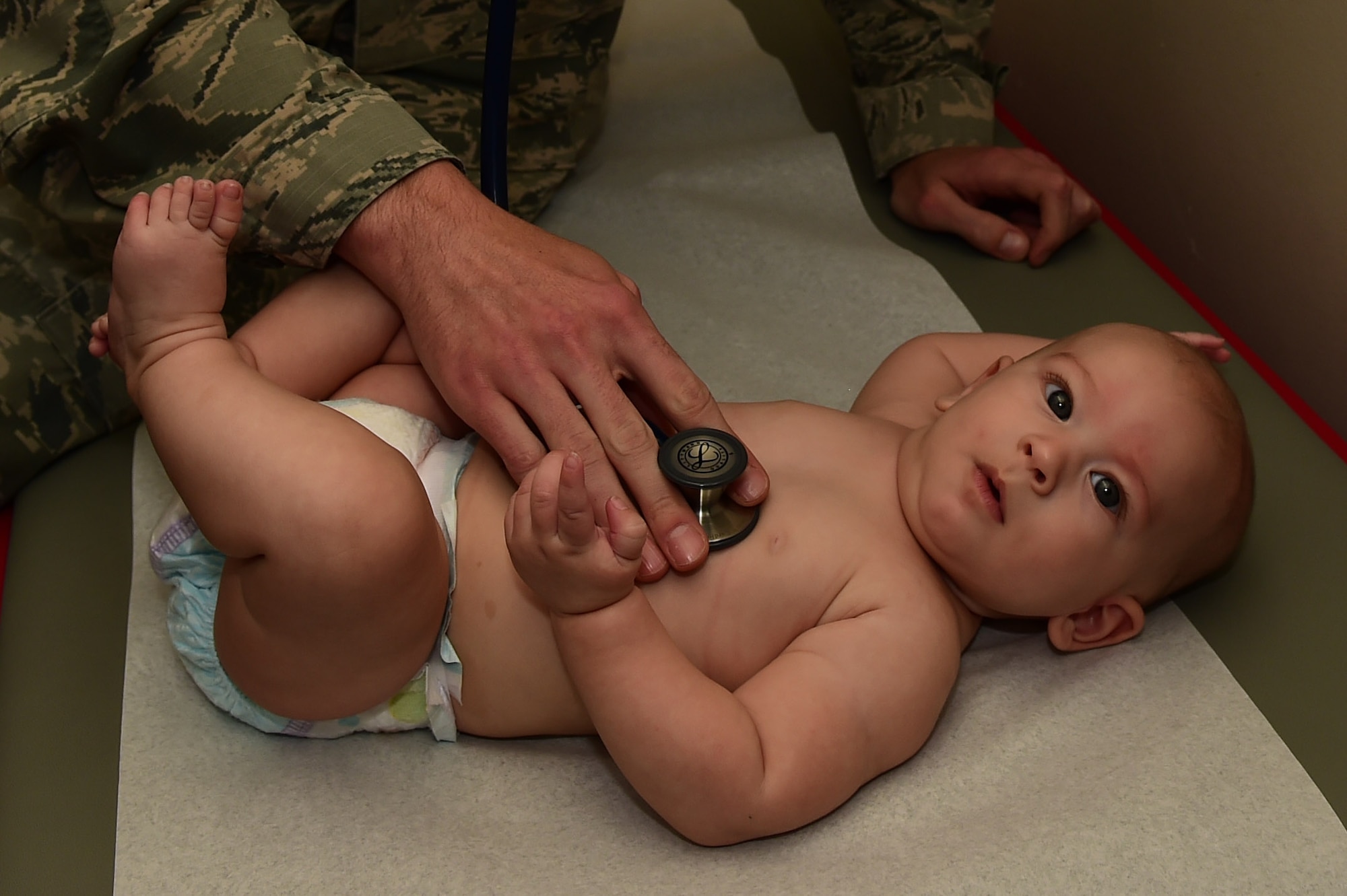 Maj. (Dr.) Michael Slogic, 460th Medical Group pediatrician, listens to the heart of Brandon Hibner, 460th MDG patient, August, 11, 2016, during a well baby at the Veterans Affairs Joint Venture Buckley Clinic in Aurora, Colo. The clinic provides well baby checks to ensure newborns continue to develop properly. (U.S. Air Force photo by Airman 1st Class Gabrielle Spradling/Released)