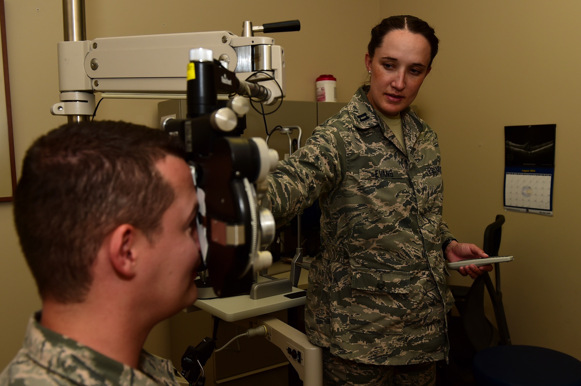 Capt. Kaylaen Evans, 460th Medical Group optometry element chief, administers a vision test to Tech. Sgt. Thomas Carrell, 460th MDG optometry NCO in charge, August 11, 2016, at the Veterans Affairs Joint Venture Buckley Clinic in Aurora, Colo. Vision tests are used to test a patient’s clarity of vision and to see if corrective lenses are needed.(U.S. Air Force photo by Airman 1st Class Gabrielle Spradling/Released)